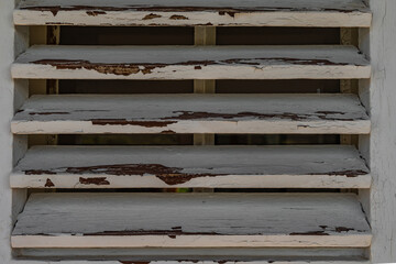 Old wooden shutters on the apartment windows, peeling paint from the windows