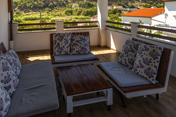 A large shaded terrace with furniture for relaxation in the attic of the tourist apartment