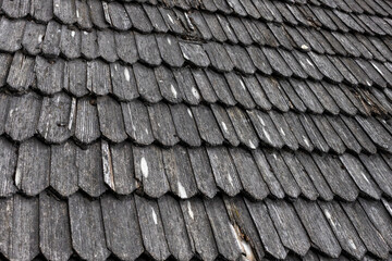 Close-up view of a weathered wooden shingle roof showcasing the texture and patterns of the shingles. neutral background, clear negative space, clean composition, balanced framing, minimalist layout