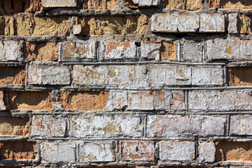 Close-up view of an aged brick wall showcasing a mix of weathered bricks and mortar, highlighting...
