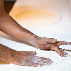 Cook hands kneading dough, piece of dough with white flour. close up on hands