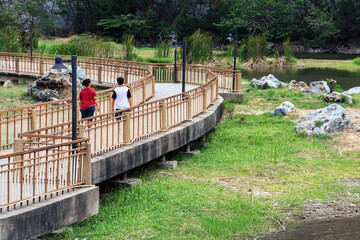 Back view of tourists come to visit and enjoy walking on the walkway with beautiful nature scenic landscape with stone mountain range also call Snake Mountain at Khao Ngu Stone Park. Amazing nature.