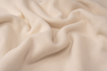 Soft milky color merino wool sweater texture as a background.