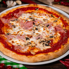 Pizza capricciosa with cooked ham, mozzarella on wooden table
