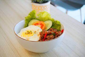 Asian Rice Bowl with Fried Egg, Stir-Fried Meat, and Fresh Vegetables – Healthy Homemade Meal on White Table