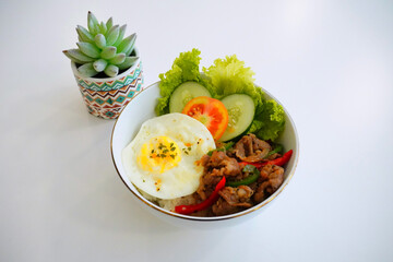 Asian Rice Bowl with Fried Egg, Stir-Fried Meat, and Fresh Vegetables – Healthy Homemade Meal on White Table