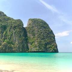 Obraz premium View from Maya Bay beach to limestone mountains in Phi Phi archipelago covered with forest in Andaman Sea. Concept of nature reserves, tourist destinations, summer holidays