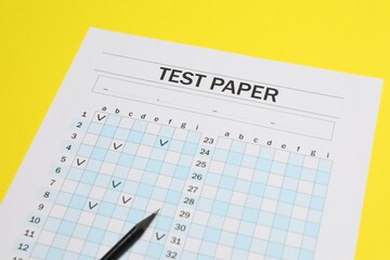 Answer sheet and pencil on yellow background, closeup. Student passing exam