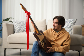 Dreams come true. Excited man with guitar at home