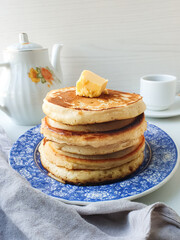golden stack of pancakes with butter on breakfast table