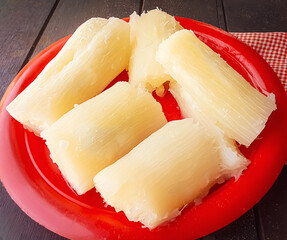 cooked cassava on a red plate and wooden background