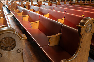 Empty church pews inside protestant church in Europe. Wide angle view, natural window light, no people