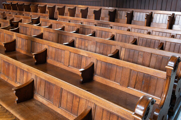 Empty church pews inside protestant church in Europe. Wide angle view, natural window light, no people