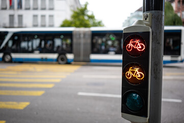 Bicycle traffic light next to pedestrian crossing, showing red and yellow. Close up, wide angle...