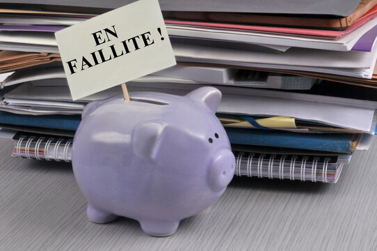 Concept de d&eacute;ficit budg&eacute;taire avec une tirelire et un panneau sur lequel est &eacute;crit en faillite