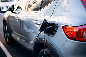 Obraz premium Electric car charging at station close up eco transport concept.