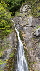 Obraz premium Aerial view of Sutovsky waterfall cascading through lush forest in Mala Fatra National Park, Slovakia. Majestic nature scene in Europe, perfect for travel, documentary and environmental projects