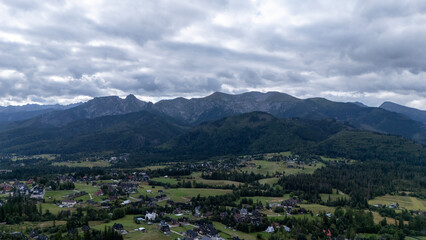 Obraz premium Mountain peaks near Zakopane, Poland, in summer. Lush green landscape with drifting clouds over alpine scenery. Ideal for nature, travel and outdoor visuals