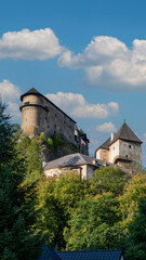 Orava Castle perched on dramatic cliffs above the Orava River in Slovakia. Sunset light reveals medieval architecture and breathtaking landscape. Ideal for history and travel visuals