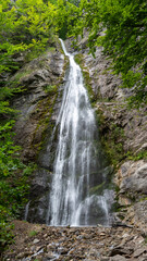 Fototapeta premium Aerial view of Sutovsky waterfall cascading through lush forest in Mala Fatra National Park, Slovakia. Majestic nature scene in Europe, perfect for travel, documentary and environmental projects