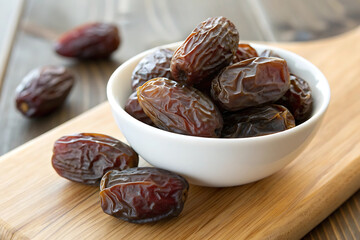 Dates in a bronze bowls on white background
