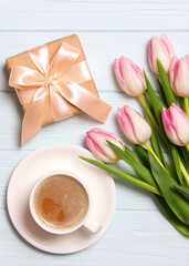 A bouquet of beautiful tulips and a gift on a wooden background top view. . Vertical photo format