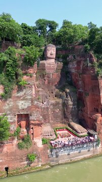 Leshan, China: Aerial orbit drone footage of the famous Leshan giant Buddha stone statue  at the confluence of the Min River and Dadu River in Sichuan in China.