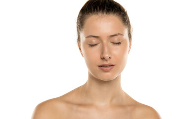 Studio shot of young woman with no makeup headshot eyes closed on white background. © vladimirfloyd