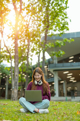 Obraz premium Asian female student in warm clothes using phone to chat with friends and ready for video call while in university.