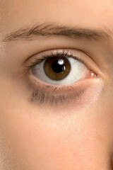 Obraz premium Studio shot closeup of young woman eye with mascara smudged under lower lashes on white background.