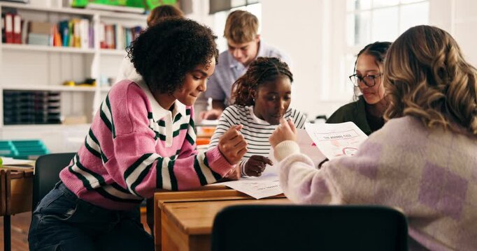 Group, classroom and students talking with notes for collaboration, learning and education. Teenagers, academy and people in discussion for knowledge, assignment and lesson feedback at high school