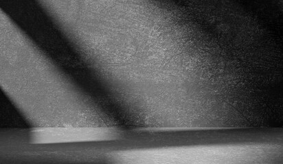 Dark light gray background with cement wall texture. Minimalist abstract background for product presentation with soft shadows from the window.