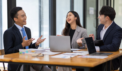 Group businesspeople happy while collaborating on a new project in an office. Businessman leading a discussion during a meeting with colleagues. Businesswoman interacting with a colleague.