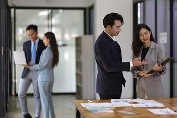 Coworkers standing and talking in the office.