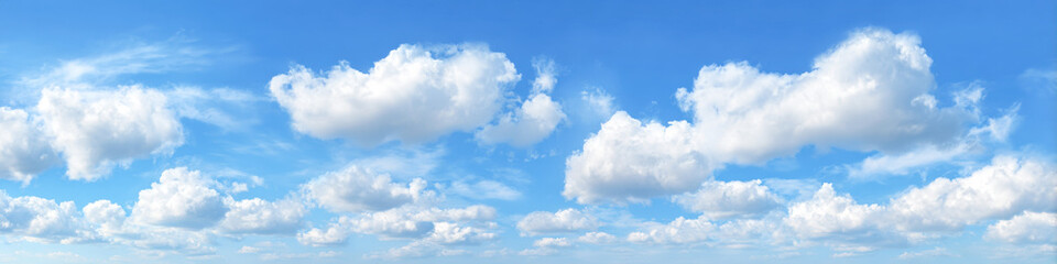 Wide expanse of clear blue sky with fluffy white clouds floating peacefully above