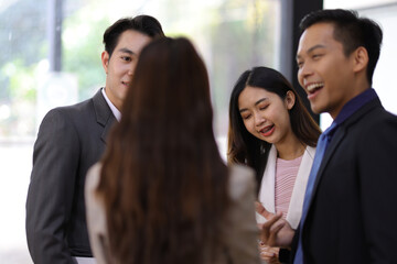 Coworkers standing and talking in the office.