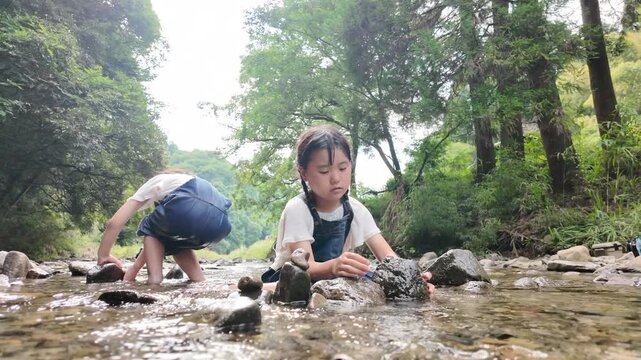 自然豊かな清流で遊ぶ子供たちの水遊び
