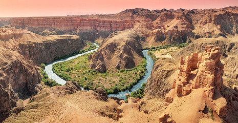 Scenic aerial view of Charyn Canyon with its colorful rock formations and the Sharyn River winding through the landscape in Kazakhstan
