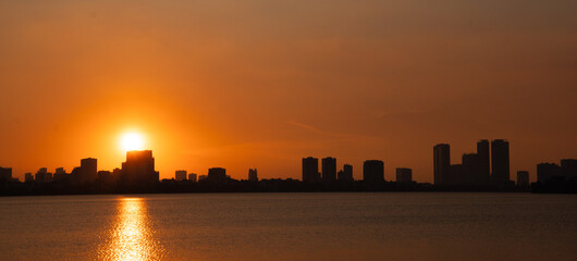 Golden sunset over the lake, silhouetted friends watching the glowing horizon in peaceful harmony.