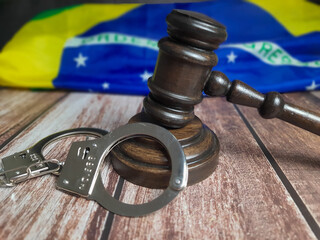 Judge's gavel with handcuffs and the Brazilian flag.