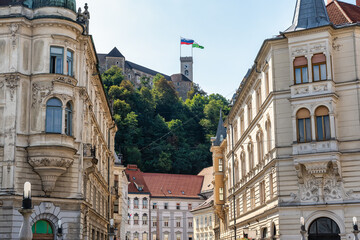 Historic buildings in Ljubljana city center with castle on top of the hill, Slovenia.