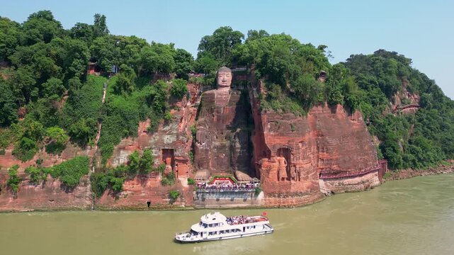 Leshan, China: Aerial drone footage of the famous Leshan giant Buddha stone statue  at the confluence of the Min River and Dadu River in Sichuan in China. Shot with an orbit motion