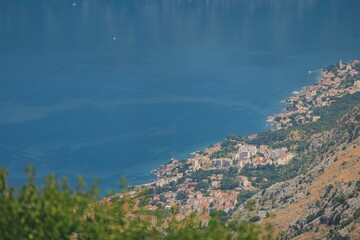 A bird's-eye perspective showcases a picturesque town hugging the shoreline of the Bay of Kotor in...