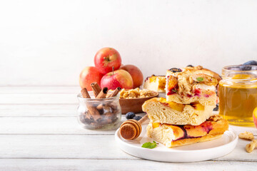 Tasty fruit dessert Focaccia. Sweet viral italian Focaccia open pie, with various seasonal autumn and summer fruits - plum, apple, figs, apricot, blueberry, peach and nuts, with spices and honey