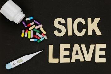 Sick leave words with medicine capsules and thermometer. Business concept of employee illness,...