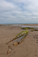 The remains of a wreck on Montrose Beach with its metal hull plates exposed by the low tide, the...