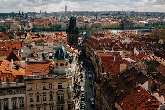 Stunning aerial view of Prague showcasing its iconic red roofs and historic architecture, with the Vltava River in the background.
