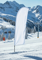 Fototapeta premium Teardrop flag mockup blank white banner in the snow at a ski resort for a winter sports event