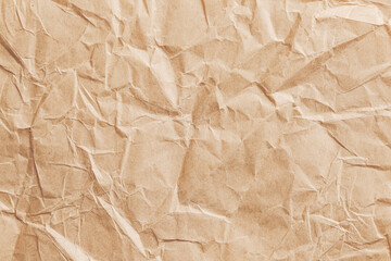 Crumpled brown paper texture background. Recycled eco material. Wrinkled surface pattern. Natural kraft packaging design. Decorative rough sheet detail. Craft wrapping element concept.