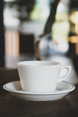 Hot coffee in white mug with dark backdrop. Freshly brewed coffee against black background. Cup of coffee on dark background.